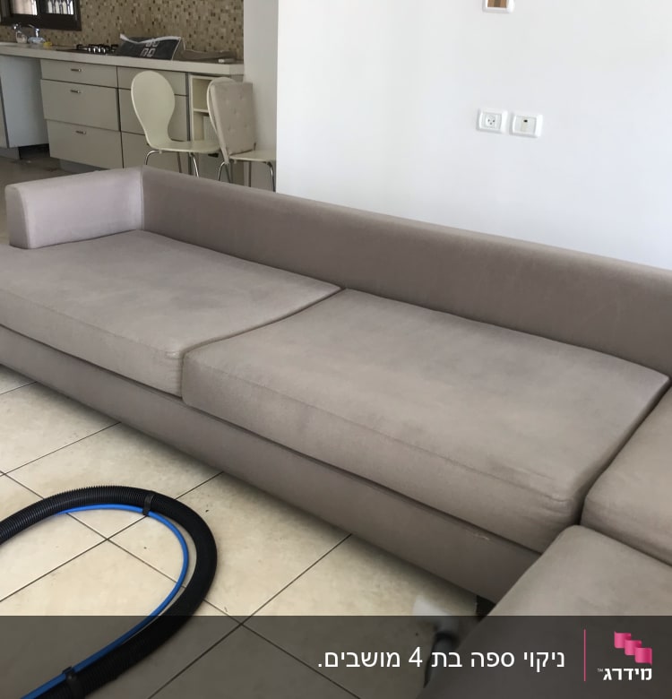 ספה אפורה עם צינור ניקוי על הרצפה